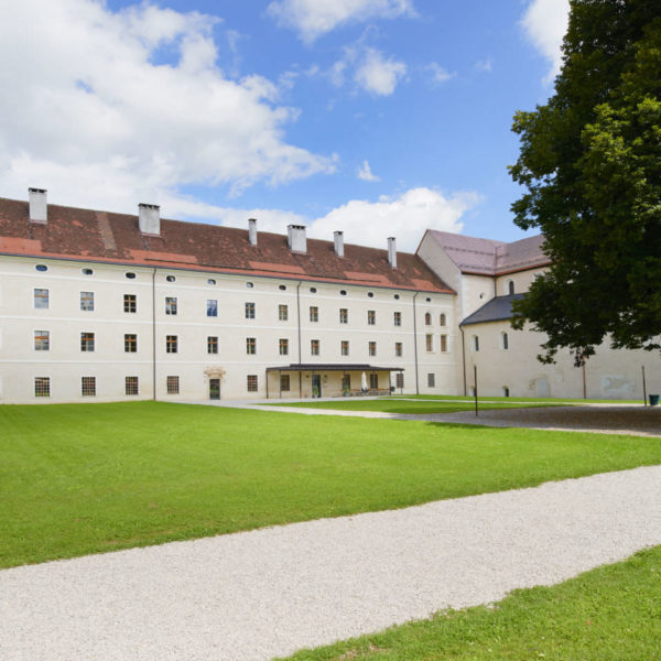 Sie sehen eine Aussenansicht mit Wiese und Baum vom JUFA Hotel Stift Gurk im Sommer. JUFA Hotels bietet Ihnen den Ort für erlebnisreichen Natururlaub für die ganze Familie.